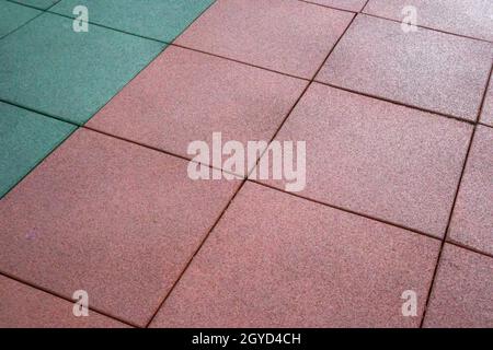 Künstliche gummierte Beschichtung für Spielplätze. Synthetisches Material. Farbenfrohe Kulisse für einen Spielplatz im Freien bei regnerischem Wetter. Aktiver Lebensstil, Arbeitswelt Stockfoto