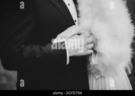 Braut und Bräutigam an einem regnerischen Hochzeitstag, der unter einem Regenschirm läuft Stockfoto