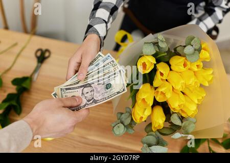 Frau Floristin verkauft Blumen an einen Mann. Blumenladen Stockfoto