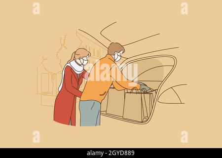Shopping während Coronavirus Epidemie Konzept. Junge Familie trägt medizinische Schutz Gesichtsmasken, die Einkaufstaschen aus dem Auto nach dem Einkaufen während C Stockfoto