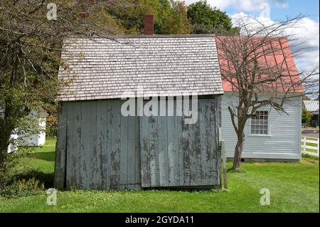 Hancock Shaker Museum, Pittsfield, Massachusetts, USA - Eine Shaker-Gemeinde, die in den 1780er Jahren gegründet wurde. Seite einer alten Lagerscheune mit dem Schulhaus Stockfoto