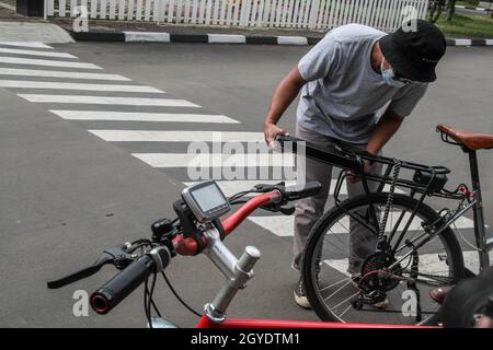 Bandung, Indonesien. Oktober 2021. Ein Mechaniker sah in der Werkstatt von Arusik Bikes in Bandung, wie er ein Batteriefach an einem Faltfahrrad installierte, das in ein Elektrofahrrad umgewandelt wird. Die Standard-Fahrrad-Innovation, die mit Strom modifiziert wird, basiert auf einem zusätzlichen Dynamo am Rad mit einem „Pedal Assist“- und „Gas-Gaspedal“-System, das bis zu 70 Kilometer hält. Die Custom-Akku-Power 'Arusik Bike' reicht von 250 bis 300 Watt bei einer Akkuladezeit von 4 Stunden von Null bis voll. Kredit: SOPA Images Limited/Alamy Live Nachrichten Stockfoto