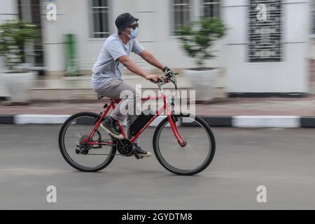 Bandung, Indonesien. Oktober 2021. Ein Mechaniker fährt ein Fahrrad, das in der Arusik Bikes Werkstatt in Bandung zu einem Elektrofahrrad umgebaut wurde. Die Standard-Fahrrad-Innovation, die mit Strom modifiziert wird, basiert auf einem zusätzlichen Dynamo am Rad mit einem „Pedal Assist“- und „Gas-Gaspedal“-System, das bis zu 70 Kilometer hält. Die Custom-Akku-Power 'Arusik Bike' reicht von 250 bis 300 Watt bei einer Akkuladezeit von 4 Stunden von Null bis voll. Kredit: SOPA Images Limited/Alamy Live Nachrichten Stockfoto