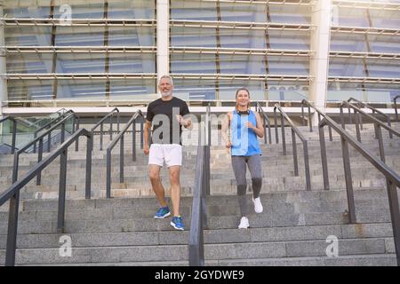 Sportlich reifes Paar, Mann und Frau im Sportswear Training gemeinsam in der Stadt am Morgen Stockfoto