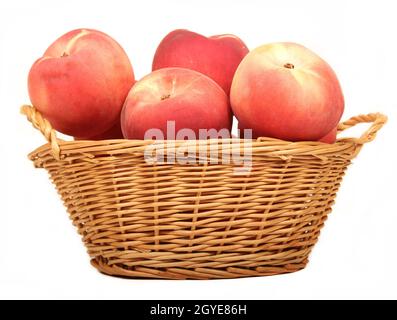 Frische Pfirsiche im Weidenkorb auf weißem Hintergrund Stockfoto