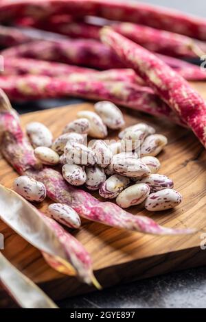 Cranberry-Bohnen. Bohnen Schoten auf einem Schneidebrett. Stockfoto