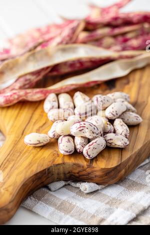 Cranberry-Bohnen. Bohnen-Pads auf Schneidebrett. Stockfoto