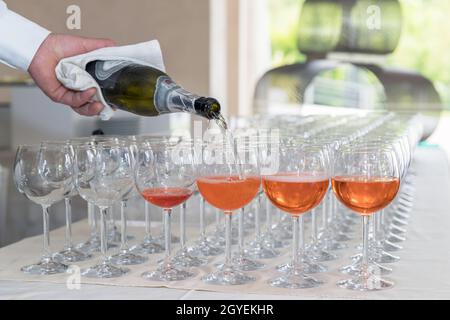 Der Barkeeper macht einen Spritz-Cocktail. Barkeeper serviert Orangenlikör-Cocktail in vielen Weinglas. Stockfoto