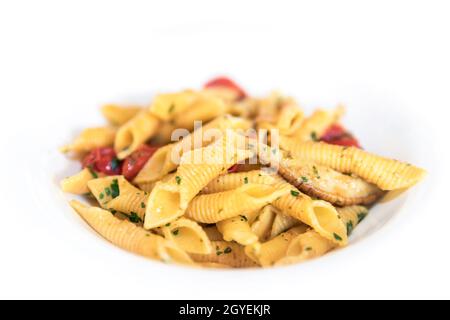 Rustikale Penne italienische Pasta mit Pilzen, Kirschtomaten, Basilikum und Olivenöl. Nahaufnahme. Flacher Freiheitsgrad Speicherplatz kopieren. Stockfoto