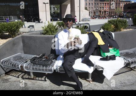 Gut gekleideter Bewohner von Harlem, der sich selbst als „Luv“ bezeichnete und sich auf dem platz im Adam Clayton Powell State Building in der 125th Street erholte. Stockfoto