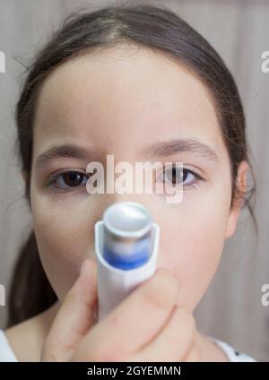 Kind Mädchen mit medizinischen Spray für den Atem. Inhalator. Vorderansicht Stockfoto