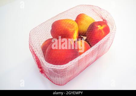 Nektarinen auf der Plastikverpackung abgedeckt. Nahaufnahme Stockfoto