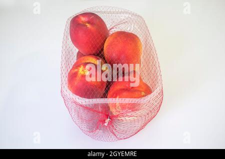 Nektarinen auf der Plastikverpackung abgedeckt. Nahaufnahme Stockfoto