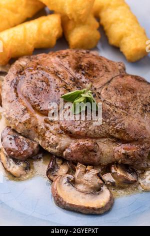 Nahaufnahme eines Schweinesteaks auf Pilzsauce Stockfoto