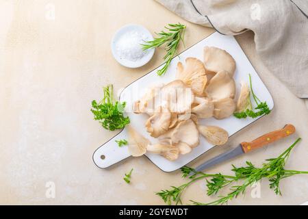 Bio Austernpilze mit Kräutern und Salz auf Schneidebrett Stockfoto