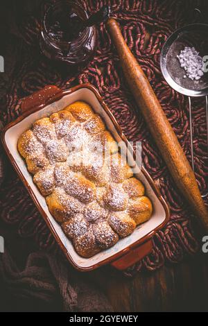 Buchteln gefüllt mit Pflaumenkonfitüre oder Gelee, süße Brötchen mit Backzutaten Stockfoto