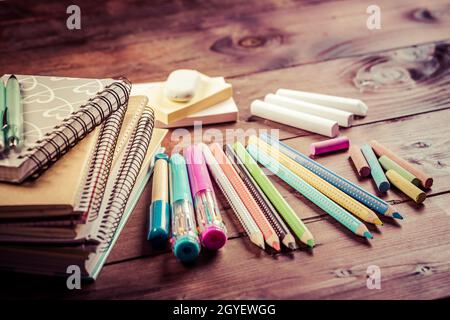 Schulbedarf mit Übungsheft und Notizbüchern auf Holzhintergrund. Zurück zum Schulkonzept. Stockfoto