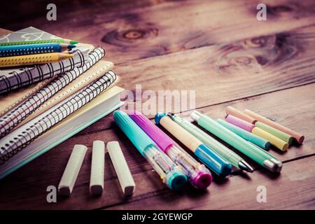 Schulbedarf mit Übungsheft und Notizbüchern auf Holzhintergrund. Zurück zum Schulkonzept. Stockfoto