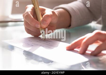 Gehaltsabrechnung Prüfen. Kassierer Unterzeichnet Check In Scheckbuch Stockfoto