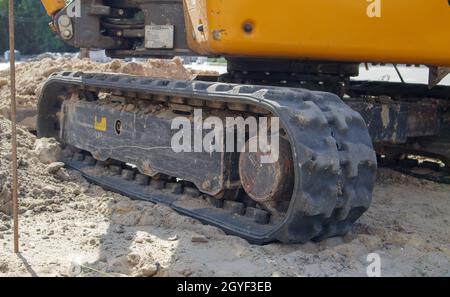 Zwei kleine Bagger auf einer großen Baustelle. Leuchtend grün auf Rädern und gelb auf Schienen. Erdarbeiten und Bau. Schaufelbagger. Mini lo Stockfoto