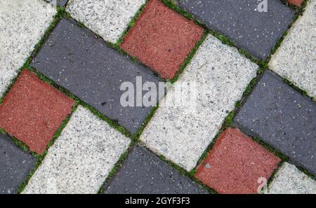 Farbiger Hintergrund und Textur neuer Pflasterplatten. Die Struktur der gepflasterten Fliesen ist rot und grau. Zement Backstein quadratischen Steinboden Hintergrund. Konz Stockfoto