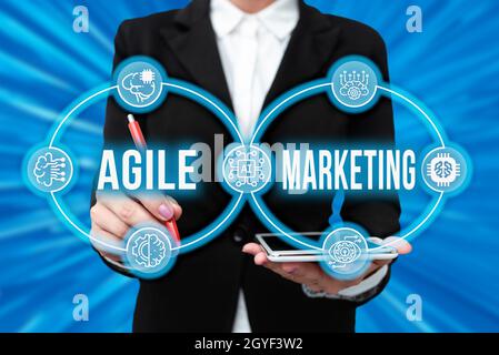 Textüberschrift mit agilem Marketing, Word für die Fokussierung von Teambemühungen, die dem Endkunden Lady einen Mehrwert bieten, in Uniform Holding Tablet in Hand V Stockfoto