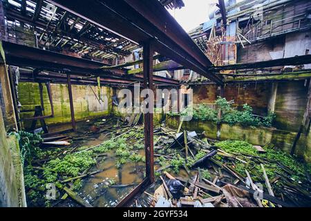 In einem großen verlassenen Gebäude mit Überschwemmungen und eingestürzten Böden Stockfoto