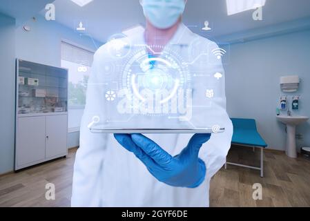 Arzt im Labor, der ein Tablet hält und futuristische Technologie zeigt. Stockfoto