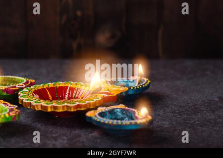 Nahaufnahme von Ton angezündeten Licht ein Feuer bereits auf Diya oder Öllampe, Studio auf Beton Hintergrund geschossen, Dekoration des Hinduismus rangoli, Happy Celebration D Stockfoto