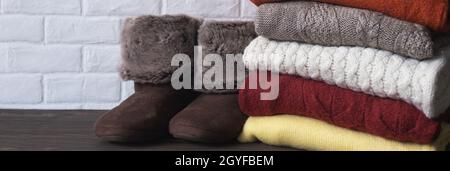 Warme Strickkleidung und Hausschuhe. Komfortable gemütliche Dinge für zu Hause. Herbst- und Winterkonzept. Banner. Stockfoto