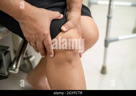 Asiatische Frau mittleren Alters Frau Patientin berühren und fühlen Schmerzen ihr Knie, gesunde medizinische Konzept. Stockfoto