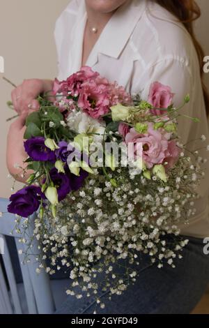 Ein Mädchen oder eine Frau hält einen Blumenstrauß. Stockfoto