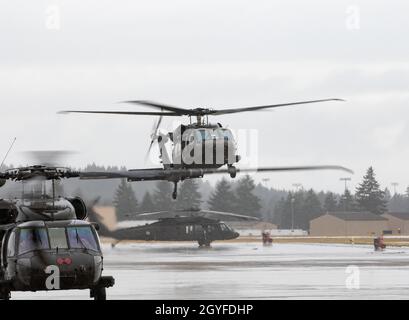 UH-60 Black Hawk-Hubschrauber wurden am 5. Oktober 2021 dem 2-158 Assault Helicopter Bataillon 'Warhawks', 16. Kampfluftfahrtbrigade, Taxi auf der Joint Base Lewis-McChord, Washington, zugewiesen. Das Bataillon transportierte Soldaten des Kampfteams der Stryker Brigade 1-2 in einer kombinierten Rüstungsübung, um die Kampfbereitschaft für Notfalleinsätze zu erhöhen. (USA Foto der Armee von Kapitän Kyle Abraham, 16. Kampfluftfahrtbrigade) Stockfoto