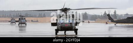 UH-60 Black Hawk-Hubschrauber, die 2-158 Assault Helicopter Bataillon 'Warhawks', 16. Kampfluftfahrtbrigade, zugewiesen wurden, laden Soldaten auf der Joint Base Lewis-McChord, Washington, am 5. Oktober 2021. Das Bataillon transportierte Soldaten des Kampfteams der Stryker Brigade 1-2 in einer kombinierten Rüstungsübung, um die Kampfbereitschaft für Notfalleinsätze zu erhöhen. (USA Foto der Armee von Kapitän Kyle Abraham, 16. Kampfluftfahrtbrigade) Stockfoto