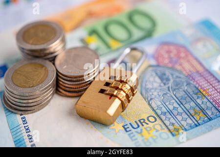 Goldene Sicherheit digitalen Passwort-Schlüssel und Münzen mit Euro-Banknoten auf Grafik, Handel Finanzierungskonzept. Stockfoto