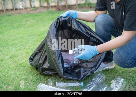 Asiatische Frau Freiwillige tragen Wasser Plastikflaschen in Müllbeutel Müll im Park, recyceln Abfall Umwelt Ökologie Konzept. Stockfoto