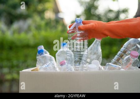 Asiatische Frau Freiwillige tragen Wasser Plastikflaschen in Müllkiste Müll im Park, recyceln Abfall Umwelt Ökologie Konzept. Stockfoto