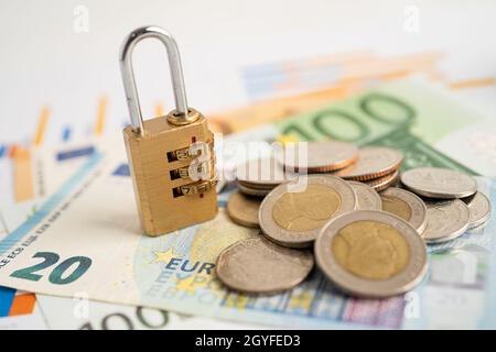 Goldene Sicherheit digitalen Passwort-Schlüssel und Münzen mit Euro-Banknoten auf Grafik, Handel Finanzierungskonzept. Stockfoto
