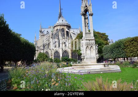 Paris - Brunnen der Jungfrau Maria auf dem Platz Jean XXIII und Ostseite der Kathedrale Notre Dame Stockfoto