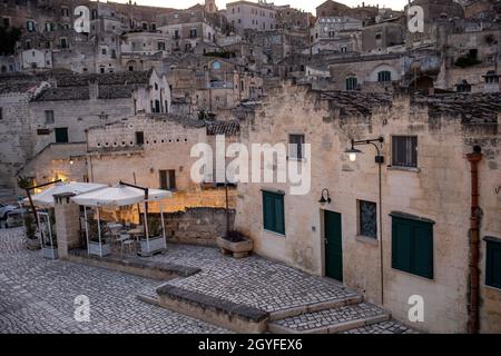 Matera, Italien - 20. September 2019: Abendansicht der Stadt Matera, Italien, mit den bunten Lichtern, die die Patios der Straßencafés im S hervorheben Stockfoto