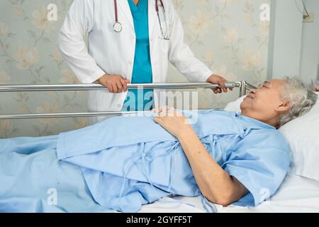 Asiatische ältere oder ältere alte Patientin legt sich hoffnungsvoll auf ein Bett im Krankenhaus. Stockfoto