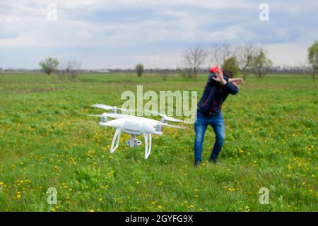 Ein Mann verbirgt sich von einer Kollision mit einer Drohne. Quadrocopter fliegt die Person. Stockfoto