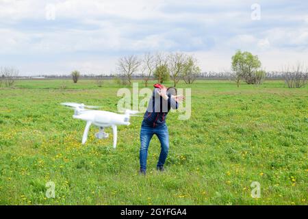 Ein Mann verbirgt sich von einer Kollision mit einer Drohne. Quadrocopter fliegt die Person. Stockfoto