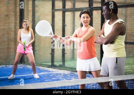 Eine Frau, die Tennis spielt und erfahrene Spieler nach Technik fragt Stockfoto