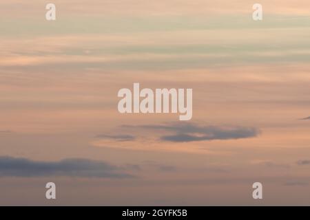 Hintergrund in Pastellfarben, der bei Sonnenuntergang von einem Himmel aus sanften Wolken gestaltet wird. Hauptsächlich orange mit etwas blau, sehr ruhig und wispy. Viel Speicherplatz für Kopien Stockfoto