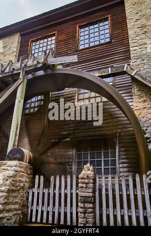 Wasserrad an der alten Mühle mit Ziegelmauern und einem Holzzaun Stockfoto