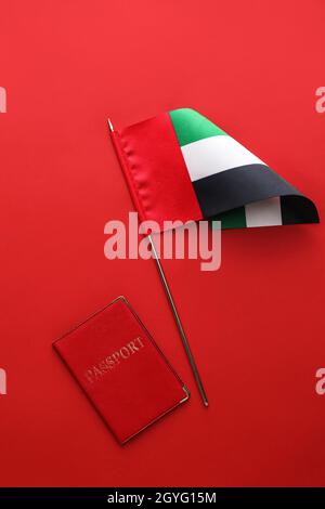 Flagge der Vereinigten Arabischen Emirate und Reisepass auf rotem Hintergrund Stockfoto