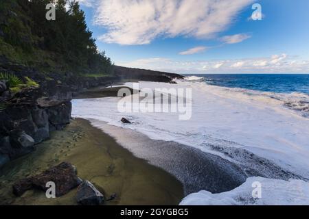 Wilder Strand mit vulkanischen Felsen auf Reunion Island mit blauem Himmel Stockfoto