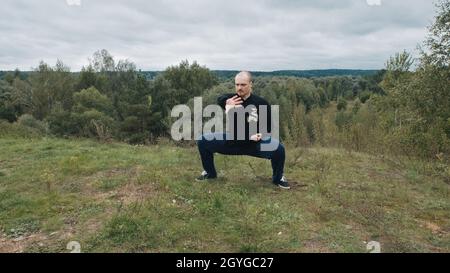 Der kaukasische Mann engagiert sich in der traditionellen chinesischen Gymnastik Qigong und Tai Chi Stockfoto