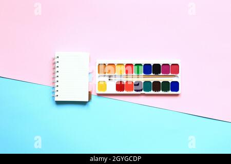 Eine Reihe von Farben und Bleistiften zum Zeichnen auf einem rosa Hintergrund. Schreibwaren für die Schule. Layout der Waren für den Künstler. Blick von oben. Stockfoto